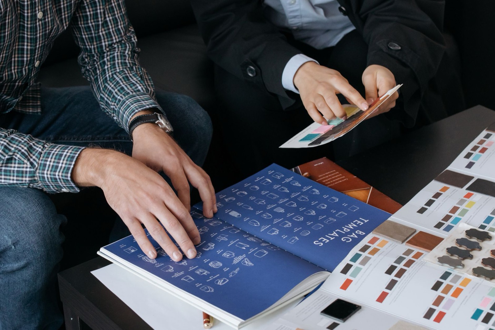 Échantillons de tote bags et stylos personnalisés posés sur une table de fabrication