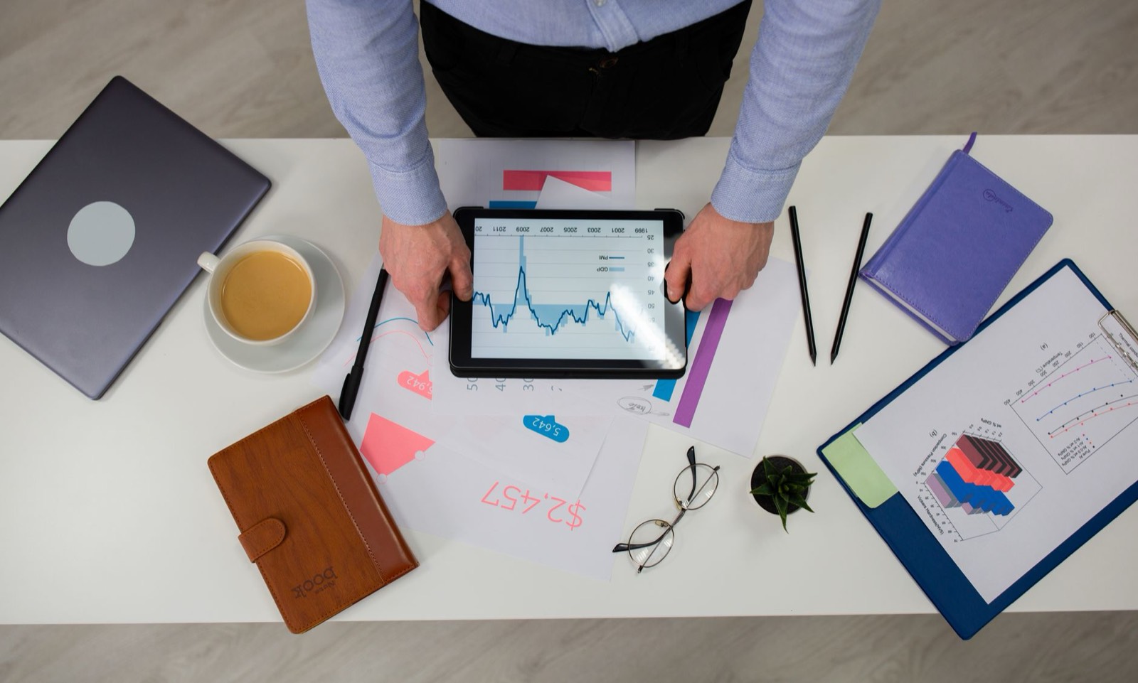 Entrepreneur lisant l'actualité économique sur une tablette à son bureau