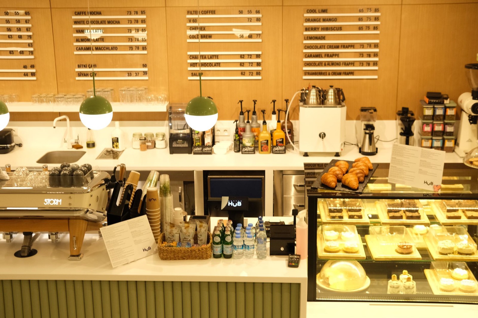 Comptoir de café avec ardoise des boissons et des prix au-dessus du bar
